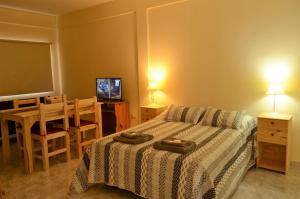 Schlafzimmer mit einem Bett, einem Tisch und einem TV in der Unterkunft City Apartments Formosa in Formosa