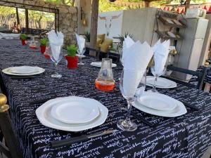 a table with white plates and wine glasses on it at Tarentaal Guest Farm in Outjo