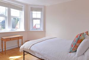 1 dormitorio blanco con 1 cama y 2 ventanas en Sea Dreams, en Eastbourne