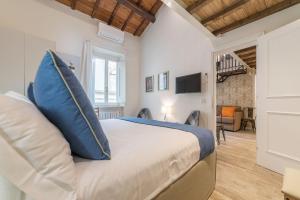um quarto com uma cama grande e almofadas azuis em CS Exclusive Campo de Fiori Palace em Roma