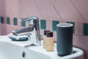 a bathroom sink with a faucet and two products on it at Hotel Cannaregio 2357 in Venice