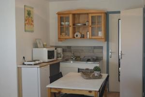 a small kitchen with a table and a microwave at gite Tombelaine in Pontorson