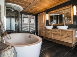 a large bathroom with two sinks and a tub at Hotel Schönegg in Wengen