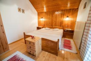 a bedroom with a bed and a wooden wall at Farm Stay Žagar in Mozirje