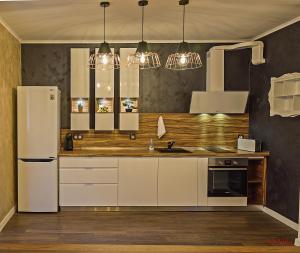 a kitchen with white cabinets and a white refrigerator at Guest House Amaya in Plovdiv