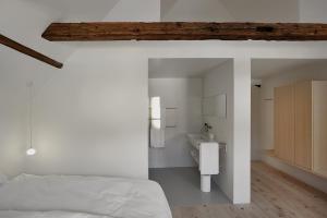 a bedroom with a bed and a sink in a room at BAR10ZIMMER in Dornbirn