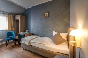 a bedroom with a bed and a table and a chair at Monopol Boutique Hotel in Bremen
