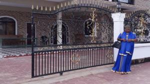 Una donna in piedi davanti a un cancello di Amir's Apartment a Nieuw Nickerie