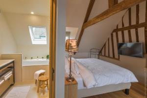 a bedroom with a bed and a staircase at La Maison de Pierre et Valérie St Leonard Honfleur in Honfleur