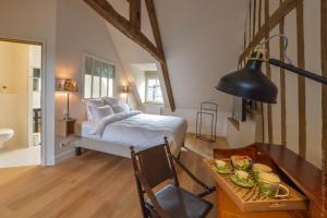 a bedroom with a bed and a table with a plate of food at La Maison de Pierre et Valérie St Leonard Honfleur in Honfleur