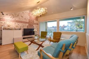 un salon avec un canapé, des chaises et une table dans l'établissement La Maison de Pierre et Valérie St Leonard Honfleur, à Honfleur