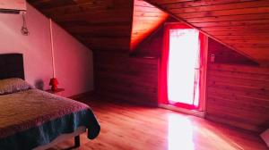 1 dormitorio con cama y ventana roja en La Louisiane, en Saint-Joseph