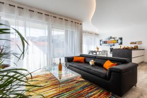 a living room with a black couch and a glass table at Villa Valis in Baška