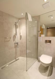 a bathroom with a glass shower and a toilet at Hamilton SPA & Wellness in Świnoujście