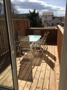 a patio with a table and chairs on a deck at La cathare appartement in Lézignan-Corbières