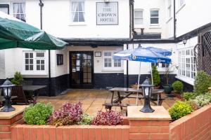 an outdoor patio with a table and an umbrella at The Crown Hotel in Alton