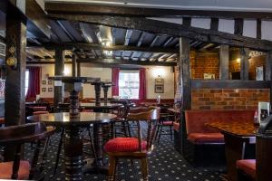 a restaurant with tables and chairs and a brick wall at The Crown Hotel in Alton