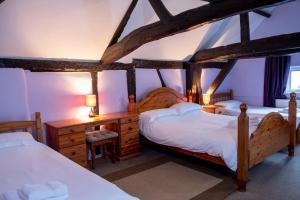 a bedroom with two beds and a desk with two lamps at The Crown Hotel in Alton