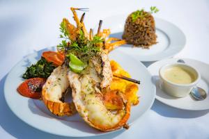 a plate of shrimp and other food on a table at Hotel Restaurant Cyvadier Plage in Jacmel