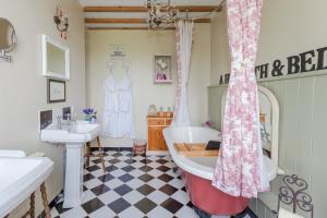 ein Badezimmer mit einer großen Badewanne und einem Waschbecken in der Unterkunft The Old Farm of Amfreville in Amfreville