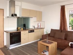 ein Wohnzimmer mit Couch und Küche in der Unterkunft Fellhornhaus Ferienwohnungen in Oberstdorf