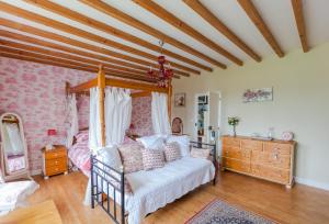 ein Wohnzimmer mit einem weißen Sofa und einem Bett in der Unterkunft The Old Farm of Amfreville in Amfreville