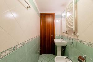 Un baño con lavabo, inodoro y espejo. en Oscar 3, en Roma
