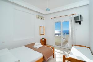 a bedroom with a bed and a window with the ocean at Villa Margarita in Limenaria