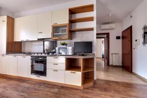 Una cocina con gabinetes blancos y una encimera con microondas. en Alba del Doge, en Mestre
