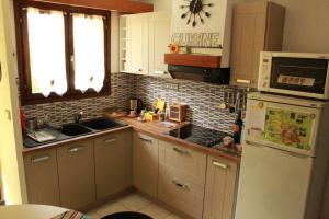 a kitchen with a sink and a refrigerator at Les champs dorés in Noyarey +64 photos