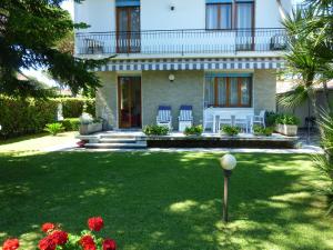 una casa con césped delante en Villa Elza, en Forte dei Marmi