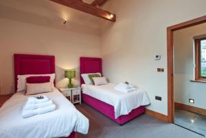 a bedroom with two beds and a window at Whytings Stud Barn 1 in Horsham