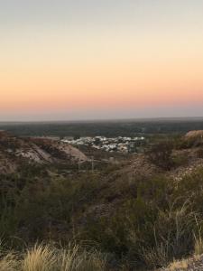 una vista desde la cima de una colina al atardecer en Apartamento Mig en Neuquén