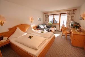 a bedroom with a large bed with flowers on it at Hotel Adler Garni in Hirschegg