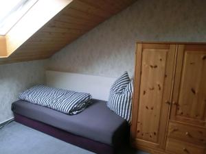 ein Bett mit zwei Kissen neben einem Schrank in der Unterkunft Ferienwohnung Gartenblick in Ensingen