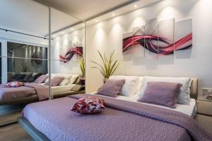 two beds in a room with paintings on the wall at Villa Valis in Baška