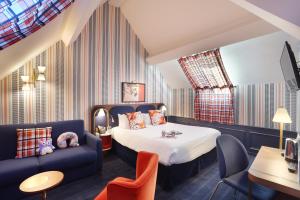pokój hotelowy z łóżkiem i kanapą w obiekcie Hob Le Cheval Blanc w mieście Jossigny