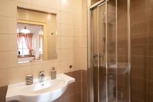 a bathroom with a sink and a shower at Restaurace a penzion Stará pošta in Bečov nad Teplou