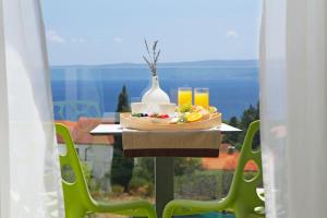 a table with a plate of food and drinks on it at Boutique Hotel Bol in Bol