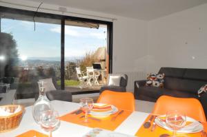 a dining room table with orange chairs and a view of the city at le havre de paix in Annecy