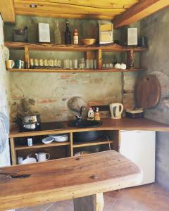 a kitchen with wooden shelves and a wooden bench at Valuntynė in Plokščiai