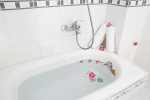 a white bath tub with a shower and flowers on it at Minh Hung Hotel in Mui Ne +24 photos