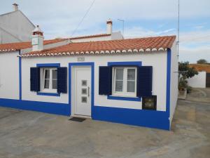 a blue and white house with a door and windows at Moradias Ode in Odeceixe