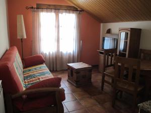 a living room with a couch and a table and a window at Apartamentos Casa Español in Broto