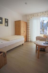 a bedroom with a bed and a couch and a table at Hotel Haus Christa in Bad Bertrich