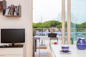 ein Wohnzimmer mit einem TV und einem Tisch mit Stühlen in der Unterkunft Appartamento Il Castello in Rimini