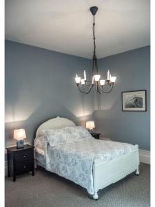 1 dormitorio con cama y lámpara de araña en Culverdene House, en Simcoe