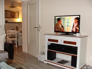 a flat screen tv sitting on top of a white entertainment center at Ferienwohnung am Nationalpark in Reifferscheid