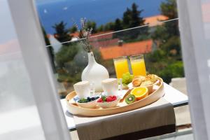 a tray of food on a table with juice and fruit at Boutique Hotel Bol in Bol