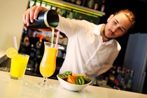 a man pouring a drink into a bowl of food at Boutique Hotel Bol in Bol
